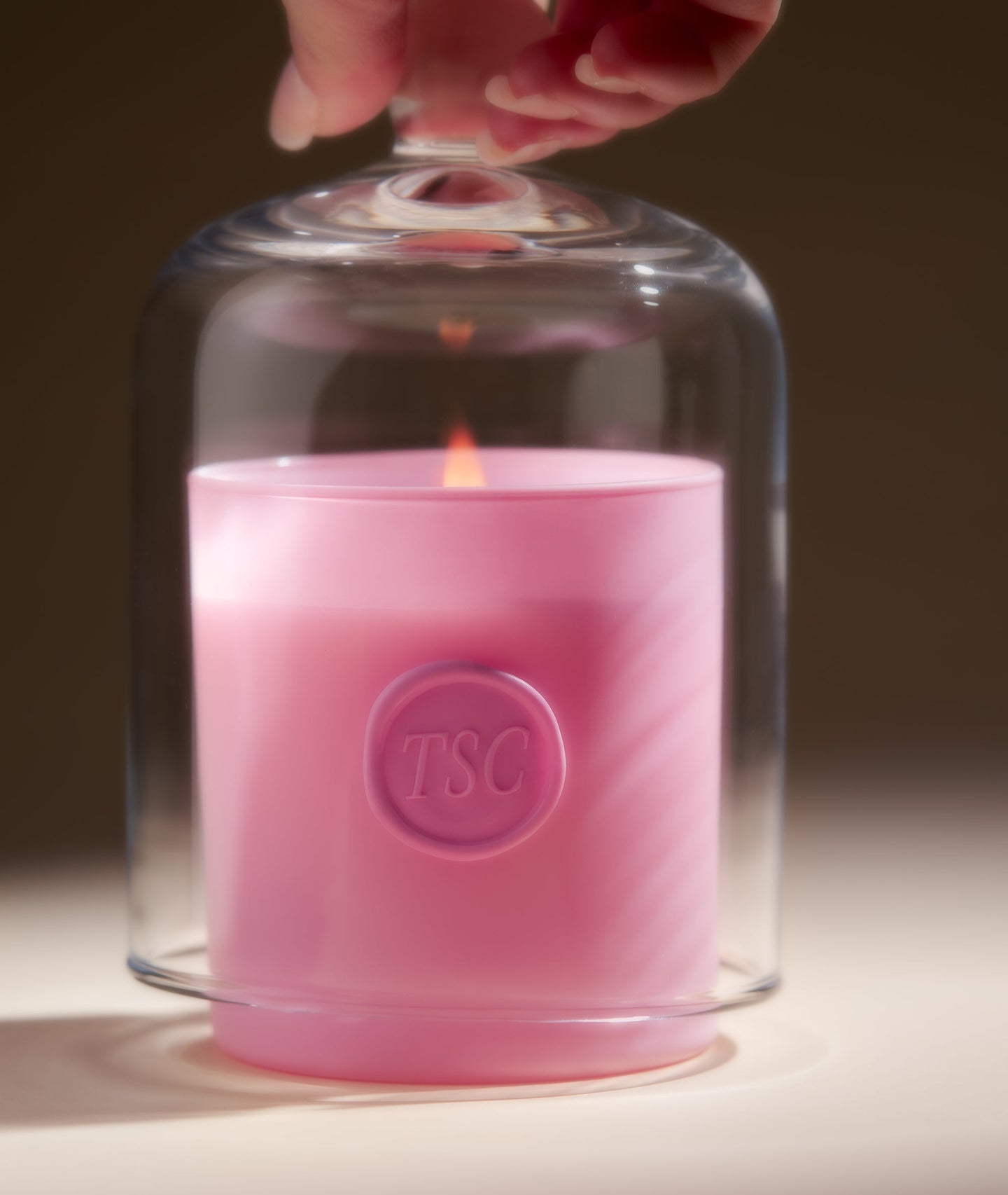 Pink candle under glass dome with flame. Pink candle under glass dome with flame.