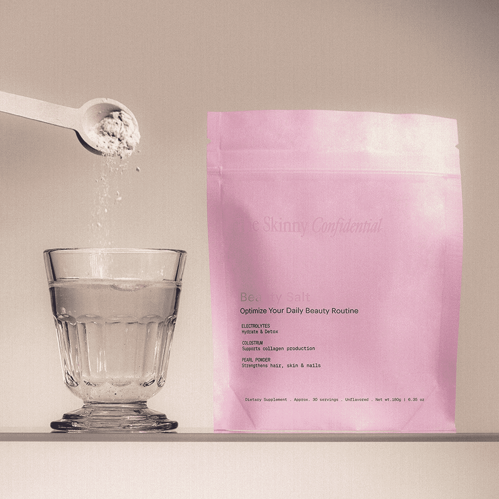 The Skinny Confidential Beauty Salt pink packaging with glass and spoon. The Skinny Confidential Beauty Salt pink packaging with glass and spoon.