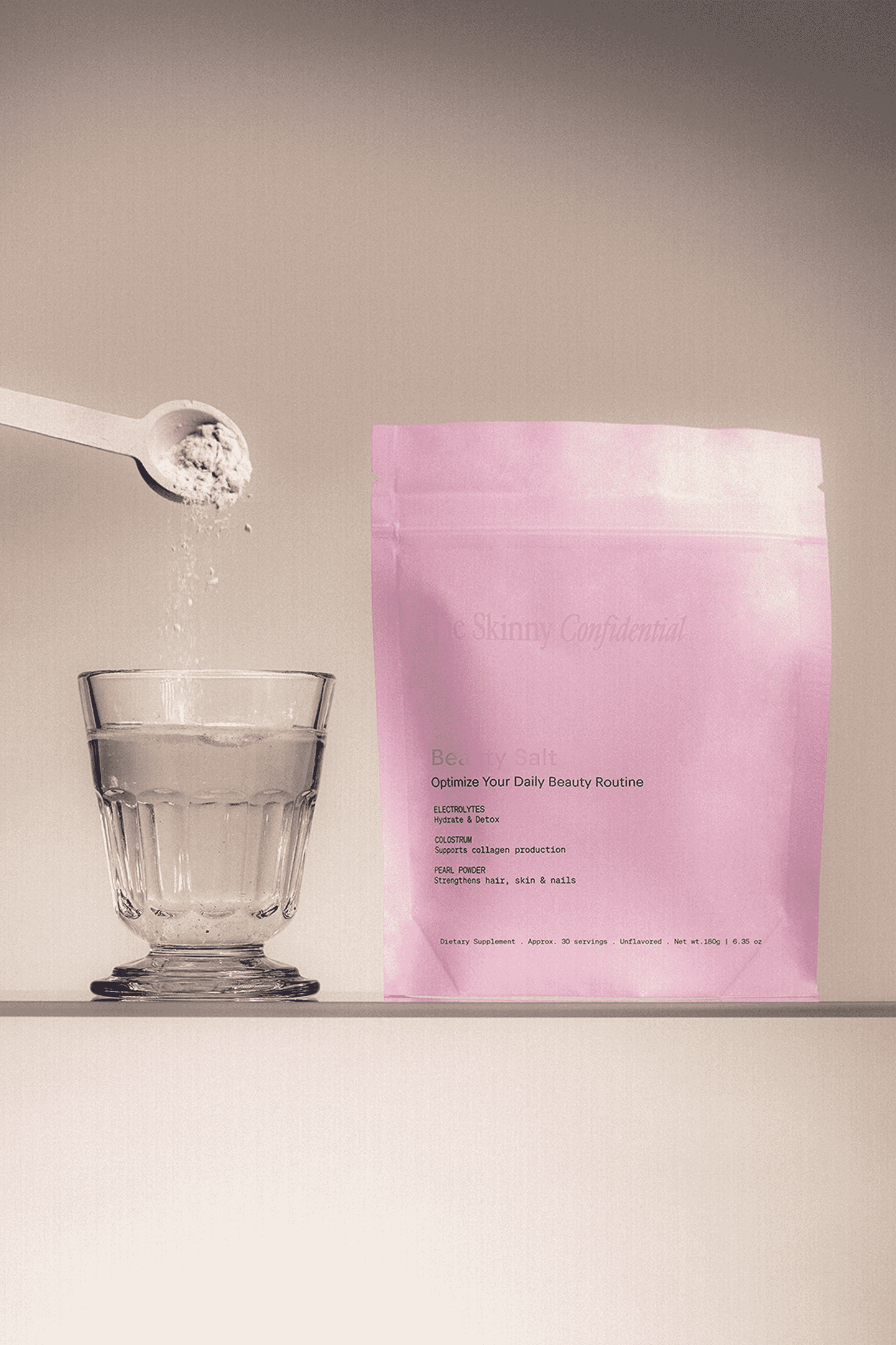 The Skinny Confidential Beauty Salt pink packaging with glass and spoon. The Skinny Confidential Beauty Salt pink packaging with glass and spoon.