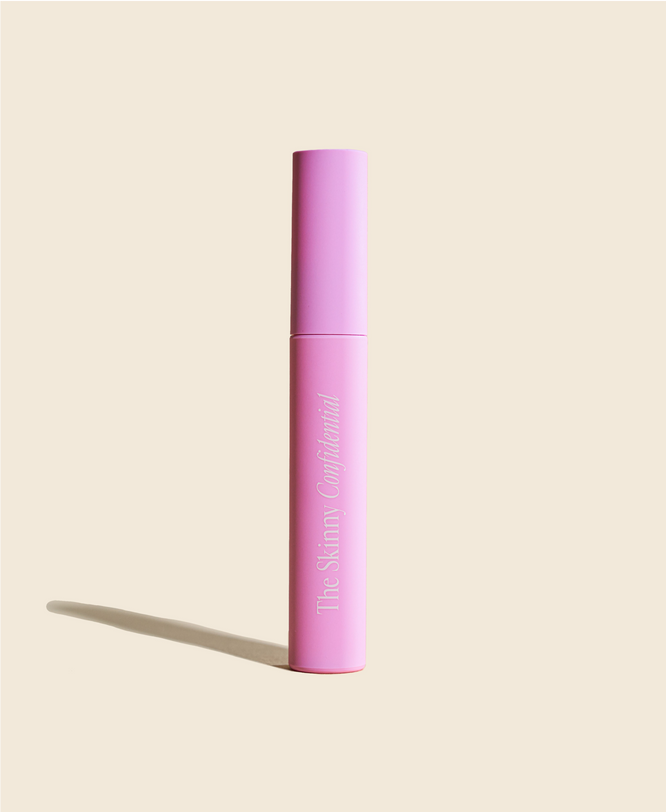 Pink mascara tube on beige background