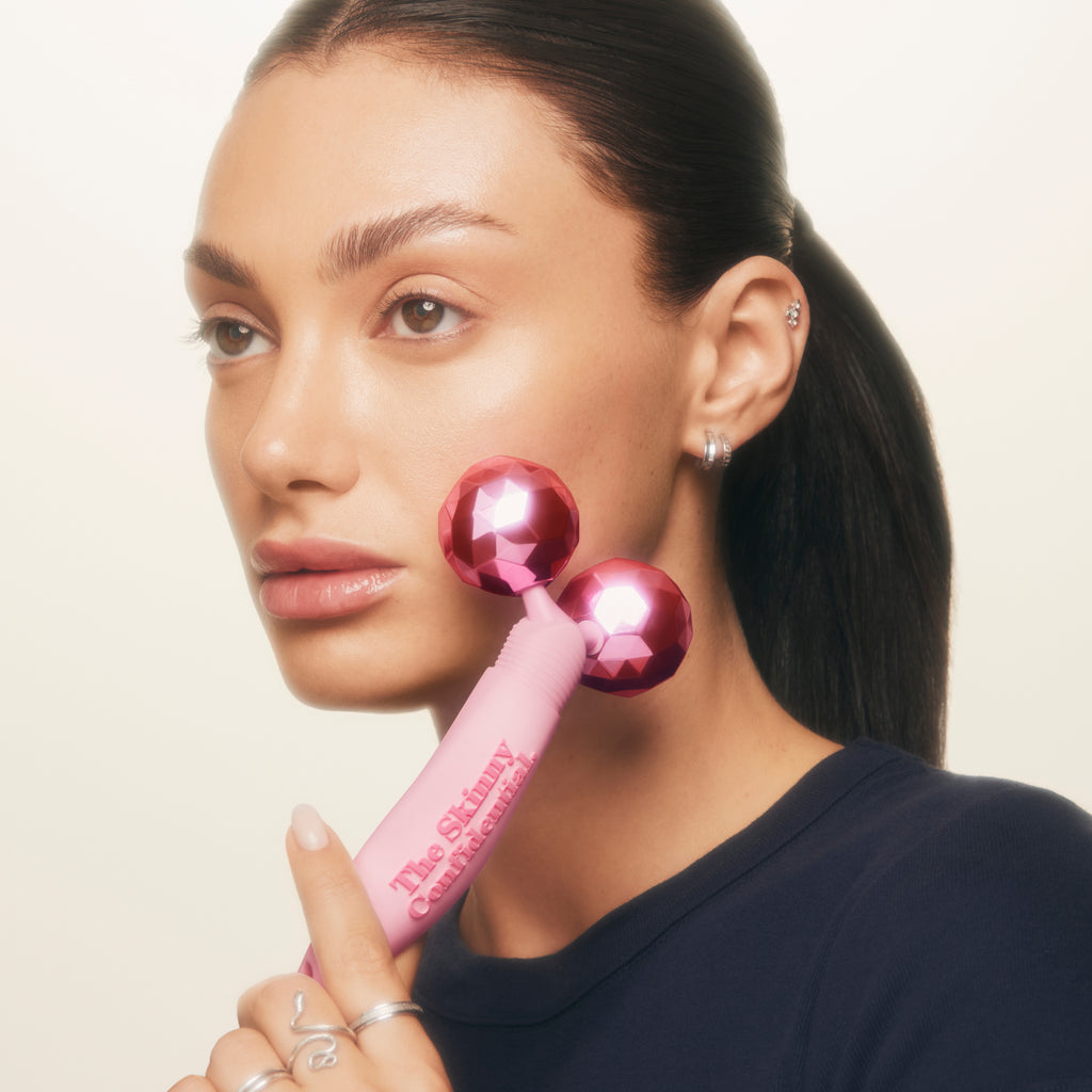 woman using pink facial roller beauty tool woman using pink facial roller beauty tool