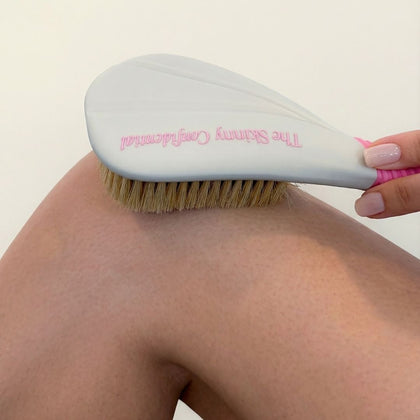 Person dry brushing their leg with The Skinny Confidential Butter Brush